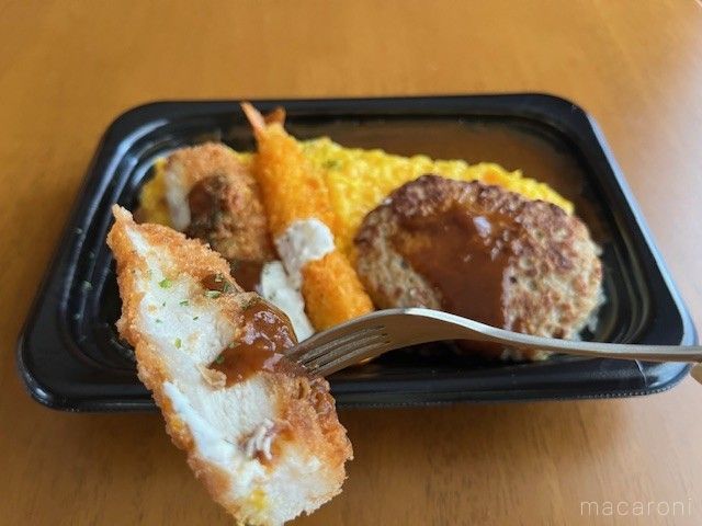 惣菜弁当のチキンカツをフォークで食べようとしている