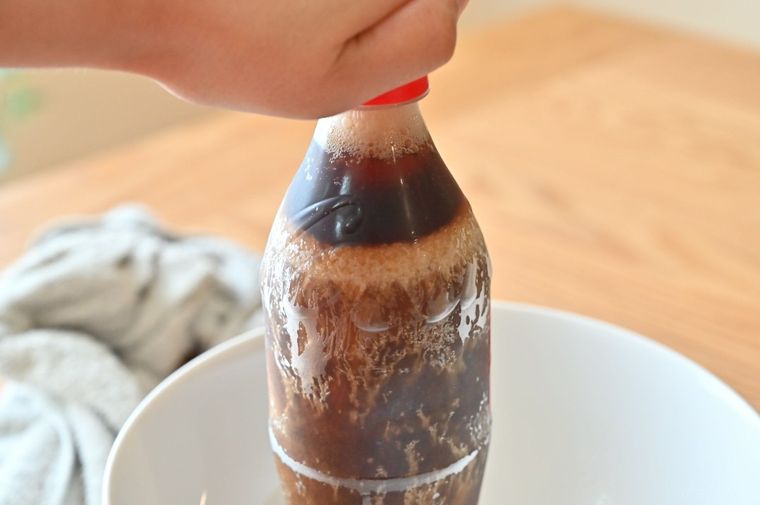 ペットボトルのキャップを開けようとしている