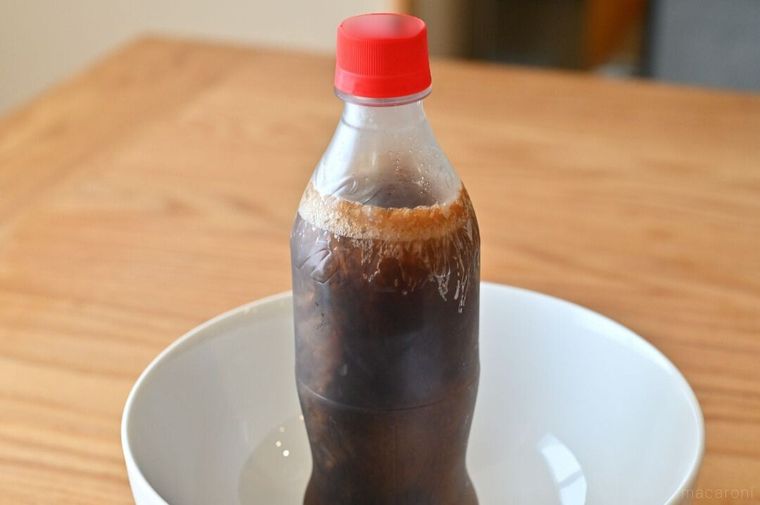 白いボウルを受け皿にしているペットボトルコーラ