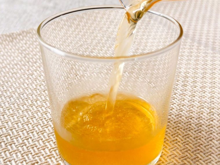  7プレミアム 濃いピーチサイダー 500mlと無糖の紅茶を混ぜたものをコップに注いでいる様子