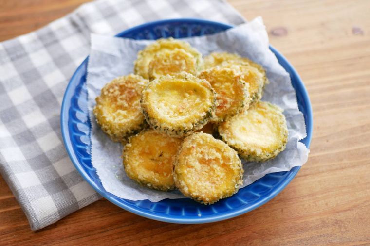 ゴーヤのワタごとカレー揚げが青い皿の上に盛られている