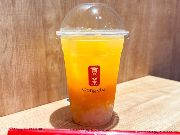 ナタデココを追加したFRESH マンゴーオレンジ ティーエードとストローが並んでいる様子