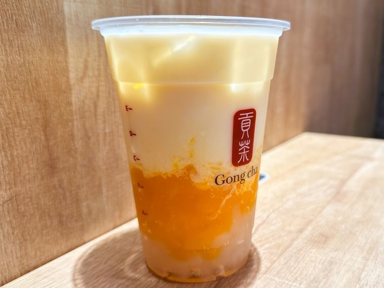 テーブルの上に置かれたFRESH マンゴーオレンジ ミルクティー