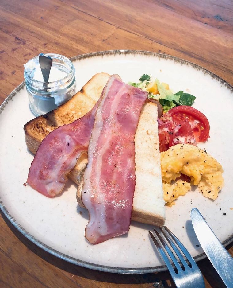 厚切りトーストにベーコンをのせ、スクランブルエッグとサラダを添えたモーニングプレート