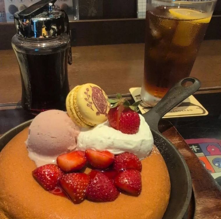 いちごとアイス、マカロンがトッピングされたパンケーキとアイスコーヒー
