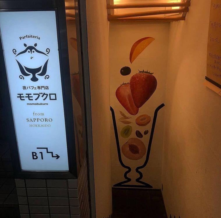 夜パフェ専門店モモブクロのフルーツパフェイラストが描かれた階段入口