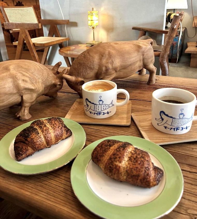 あんこクロワッサンとラテ、木彫りオブジェが並ぶマーメイドコーヒーのテーブル