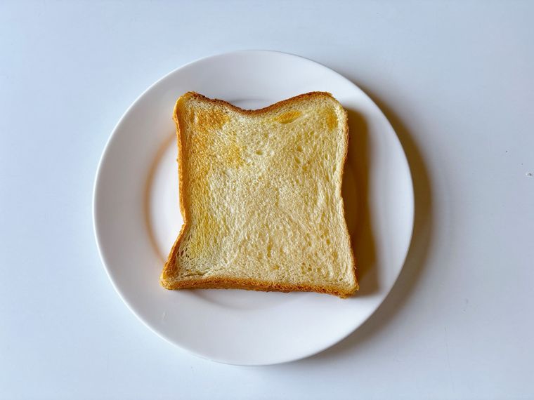 白色の皿におかれた麦茶に浸して焼いた食パン