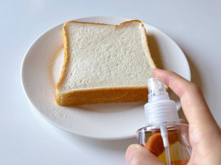 食パンの耳に麦茶を霧吹きで吹きかける様子