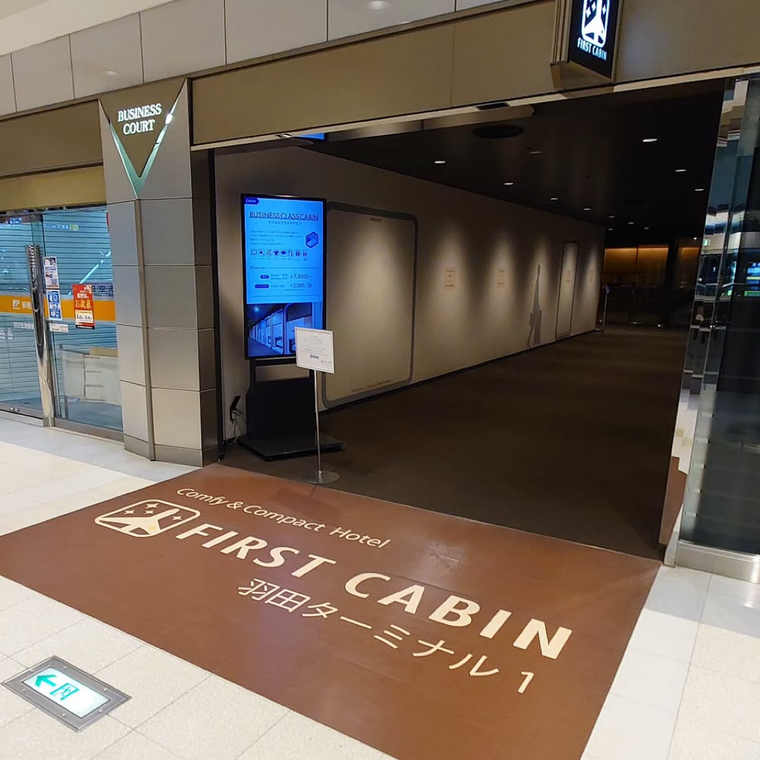 羽田空港ファーストキャビンの入口。茶色い大きなマットが敷かれ、シックな雰囲気