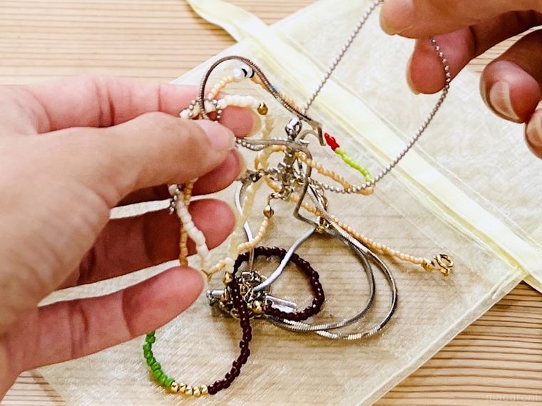 絡まったネックレスをほどいている様子