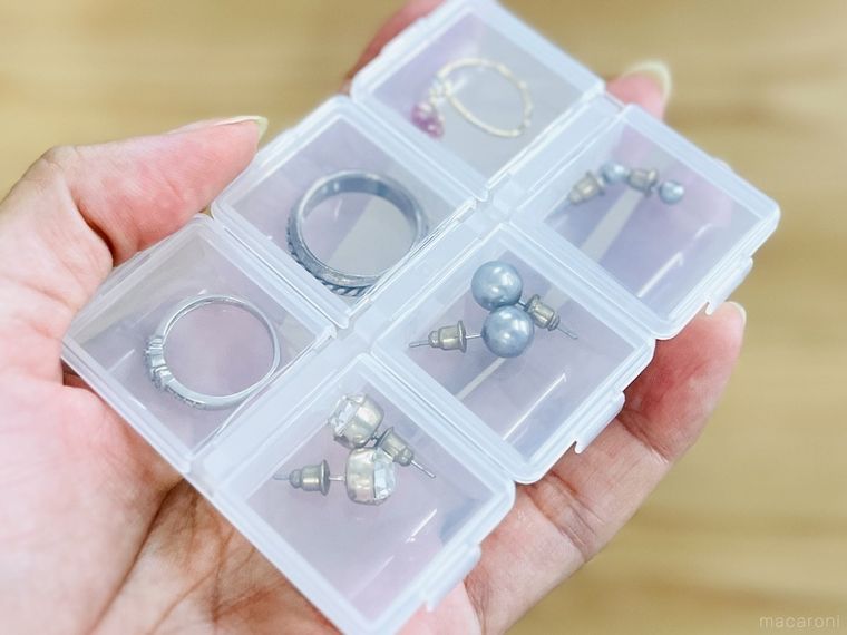ピアスと指輪が入った薬ケースを手で持っている様子
