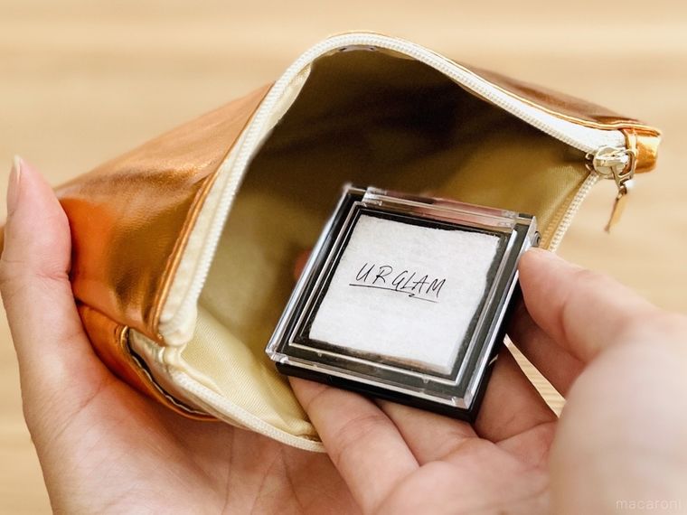 コットンを挟んだアイシャドウパレットをポーチに入れようとしている様子