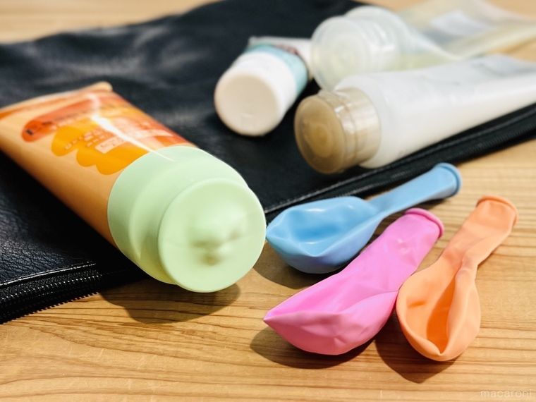 チューブ入りのアイテム、風船、黒いポーチが置かれている様子