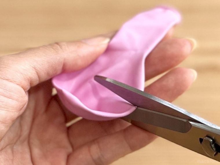 紫色の風船をハサミで切っている様子