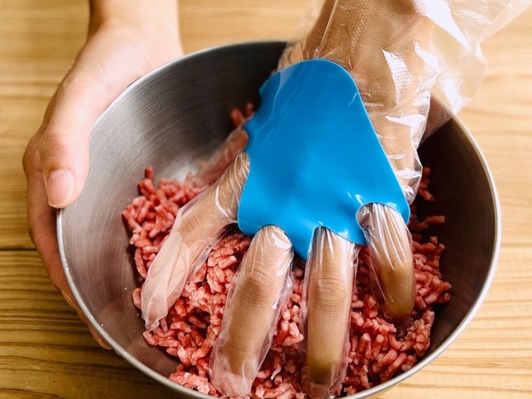 手袋ピタットをはめた手でひき肉をこねている様子