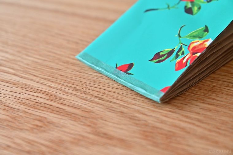 紙の束に緑のマスキングテープを貼っている