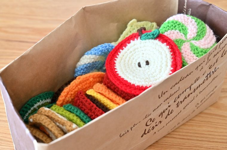 紙袋にたくさんのアクリルたわしが入っている