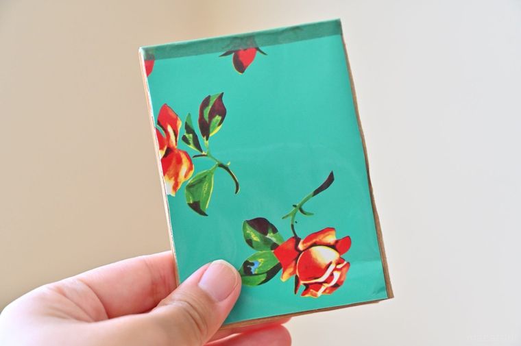 花柄の表紙がついたメモ帳を手に持っている
