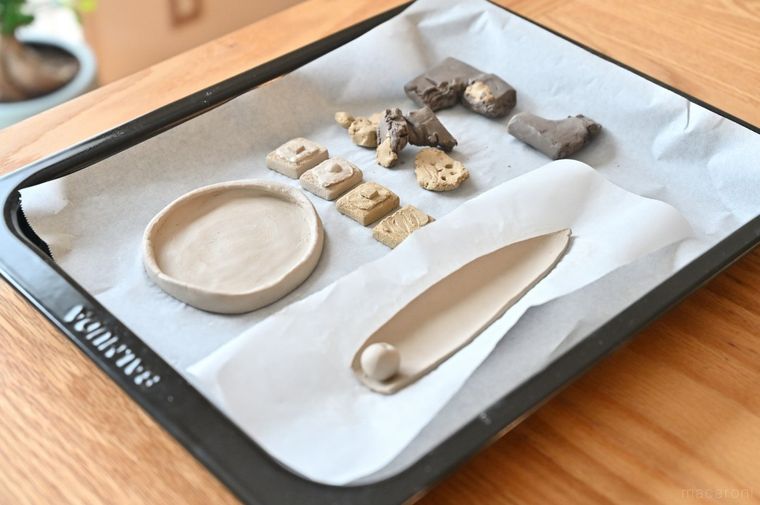 粘土作品を鉄板に並べている