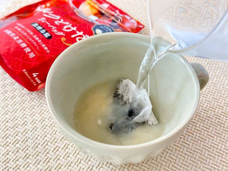 日東紅茶ミルクとけだすティーバッグ 黒糖烏龍の入ったマグカップにお湯を注いでいる様子