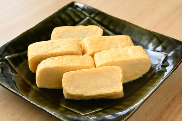 深緑色の角皿に盛り付けられただし巻き卵