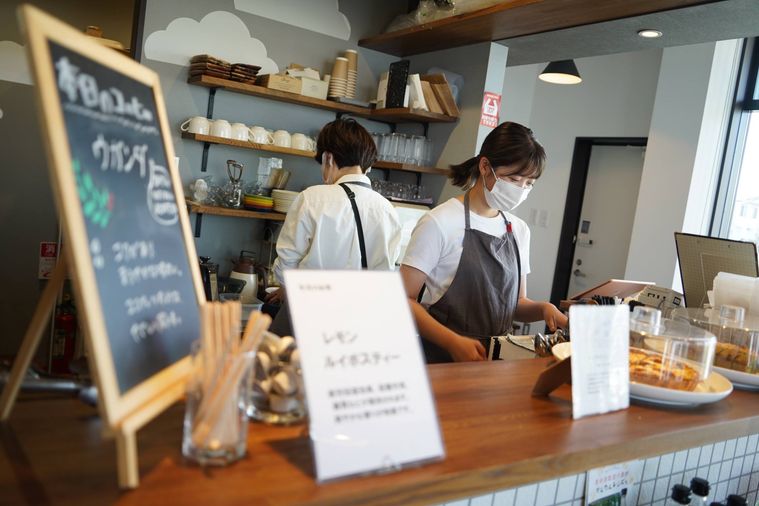 カフェの店頭に立つ早川さん