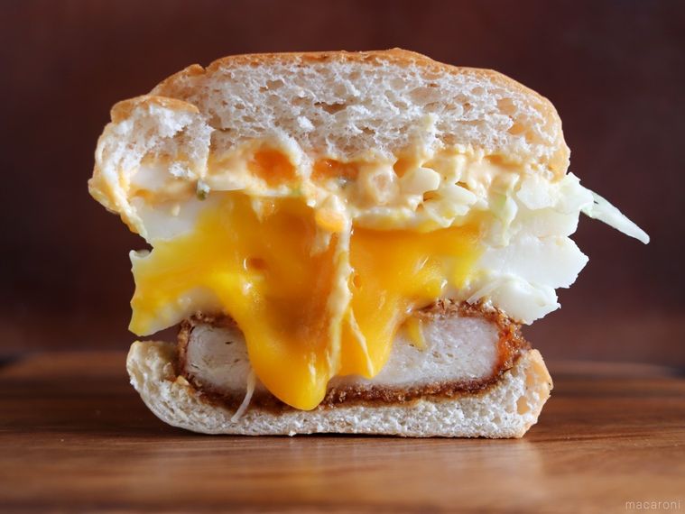 半分にカットしたケンタッキートリプル月見バーガーを木の板に置いている