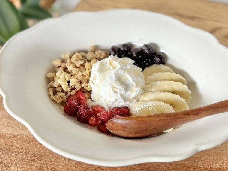 白い洋皿にヨーグルトにフルーツを盛り付けたもの