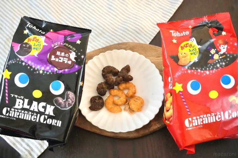 木のカッティングボードと白い皿にのったハロウィンバージョンのコーンスナックと黒色と赤色のパッケージ