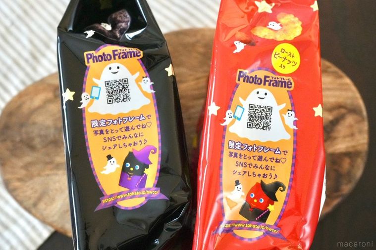 木のカッティングボードにのったコーンスナックの黒色と赤色のハロウィンパッケージのQRコードとストライプの布