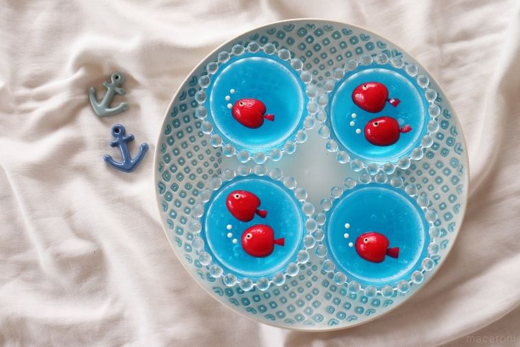 青いゼリーの上に赤い魚が浮かんでいる