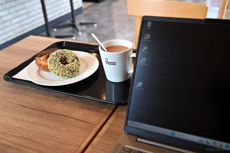 ミルクティーとドーナツを味わいながらPCを使っている