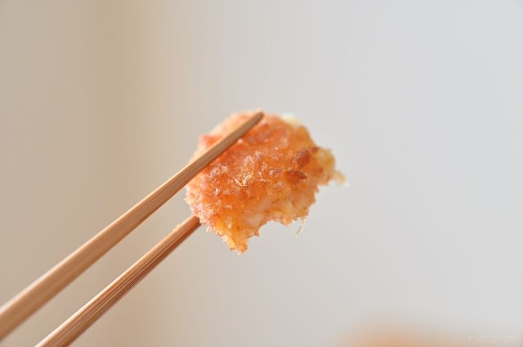 ひと口サイズのコロッケを箸でつまみあげている