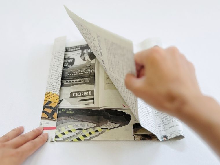 新聞紙を折っている様子