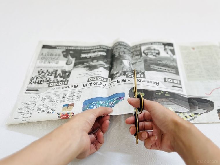 新聞紙をハサミで切っている様子