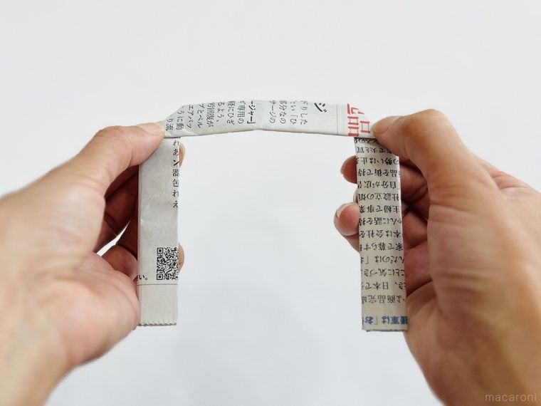 新聞紙を持ち手の形に折っている様子