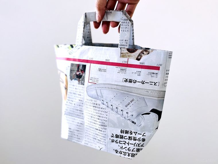 新聞紙で作ったエコバッグを手で持っている様子