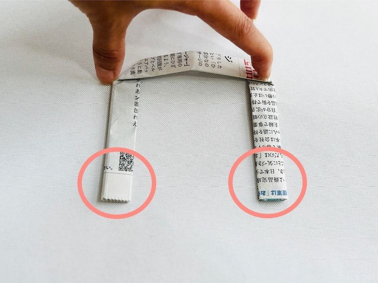 新聞紙を持ち手の形に折った様子