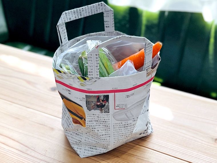 新聞紙で作ったエコバッグに野菜を入れた様子