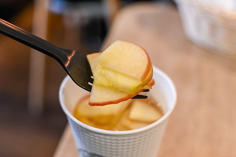 りんごのスライスをフォークで持ち上げているところ