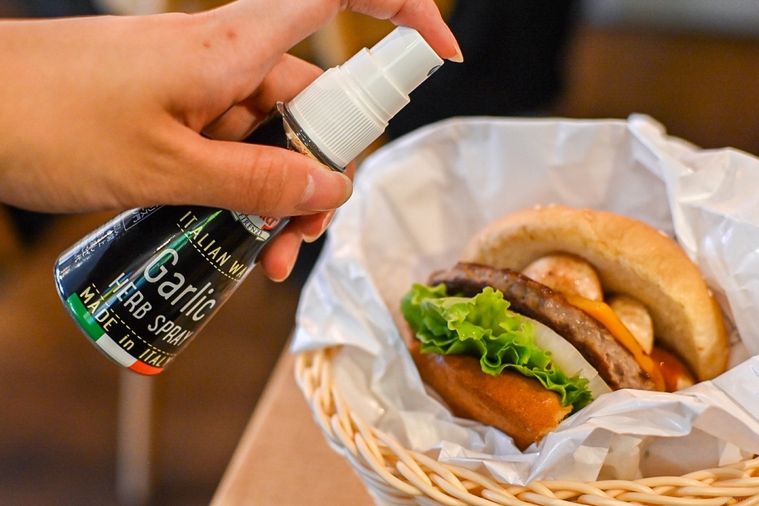 バーガーにスパイスをかけているところ