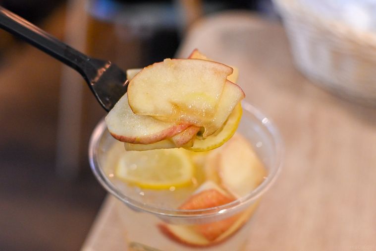 りんごのスライスをフォークで持ち上げているところ