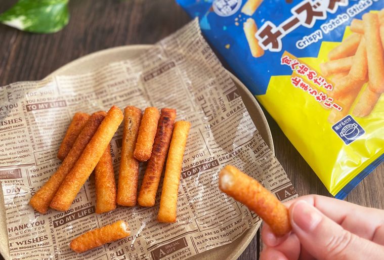 揚げたてのカリカリチーズスティックを手で持っている写真