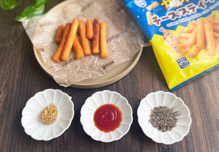 油で揚げたカリカリチーズスティックと調味料を入れたお皿