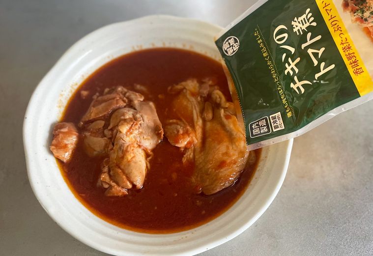 湯せんした業務スーパーチキンのトマト煮を皿に取り出している