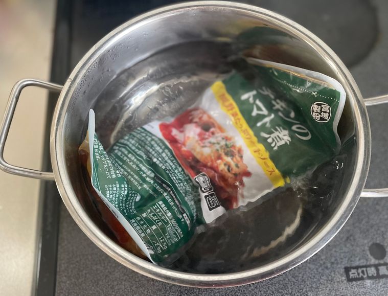 業務スーパーチキンのトマト煮を湯せんで調理している写真