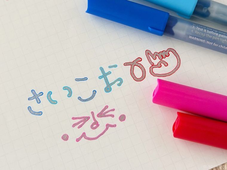 テーブルの上にふちどりマーカーと紙が置かれている様子