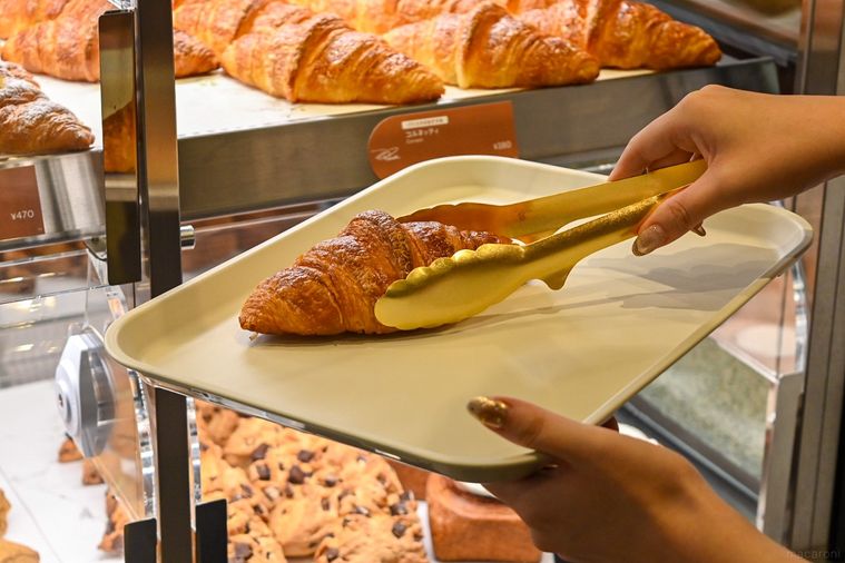 クロワッサンをショーケースから取っているところ