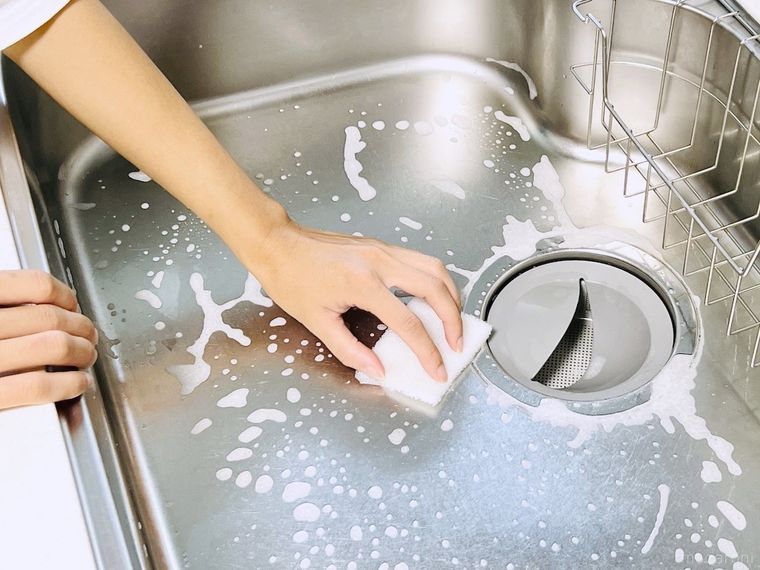 シンクをスポンジで洗っている様子